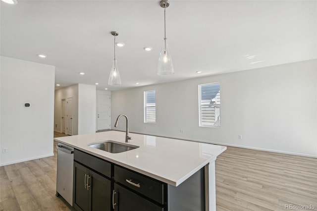 9332 Bahama Ct, Commerce City, CO 80022 - kitchen featuring a sink, light wood-style flooring, open floor plan, light countertops, and stainless steel dishwasher