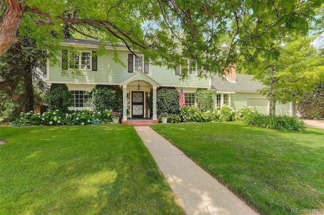 view of front of house with a garage and a front lawn