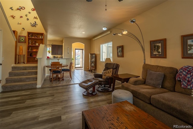 10473 Table Rock Ct Unit E, Poncha Springs, CO 81242 - living room featuring dark wood-style flooring, arched walkways, stairway, and baseboards