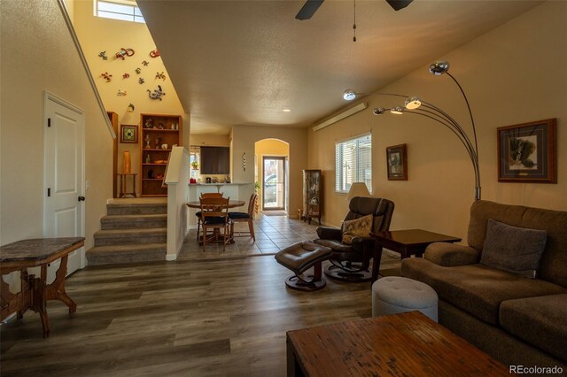 10473 Table Rock Ct Unit E, Poncha Springs, CO 81242 - living area with dark wood-style flooring, stairs, arched walkways, a ceiling fan, and baseboards