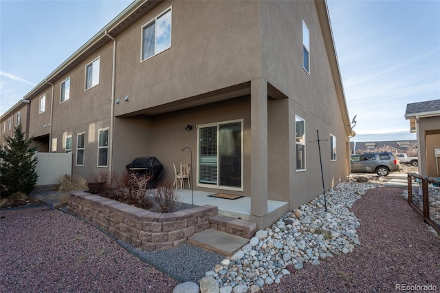 10473 Table Rock Ct Unit E, Poncha Springs, CO 81242 - rear view of property featuring stucco siding and a patio area