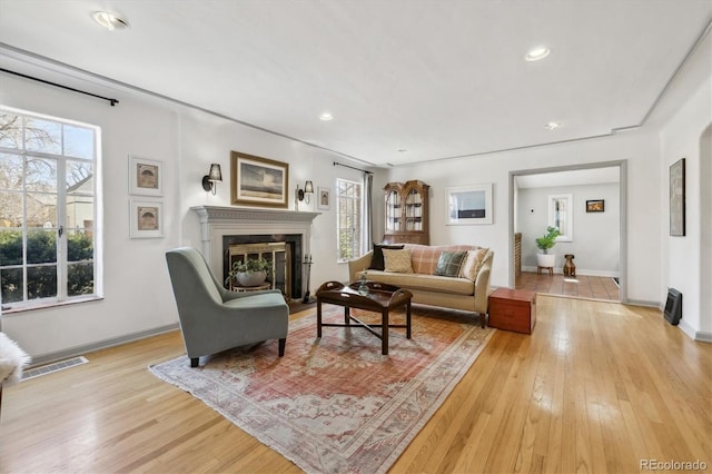 629 Bellaire St, Denver, CO 80220 - living room featuring healthy amount of natural light, light wood-type flooring, a glass covered fireplace, and recessed lighting