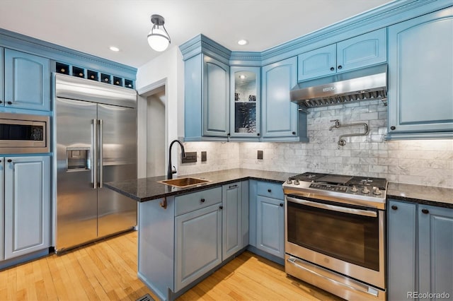 629 Bellaire St, Denver, CO 80220 - kitchen with built in appliances, a sink, under cabinet range hood, a peninsula, and light wood finished floors