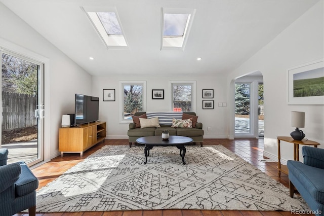 629 Bellaire St, Denver, CO 80220 - living room with vaulted ceiling, arched walkways, a skylight, baseboards, and recessed lighting