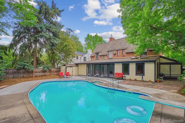 629 Bellaire St, Denver, CO 80220 - view of pool with a patio area, a fenced backyard, a sunroom, and a diving board
