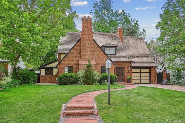 629 Bellaire St, Denver, CO 80220 - tudor-style house featuring driveway, brick siding, a front yard, and a chimney