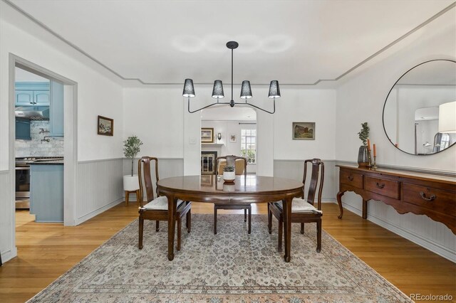 629 Bellaire St, Denver, CO 80220 - dining area with wood finished floors, wainscoting, and a glass covered fireplace