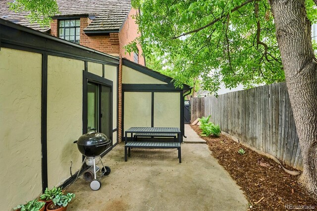 629 Bellaire St, Denver, CO 80220 - fenced backyard featuring a patio area, a grill, and a sunroom