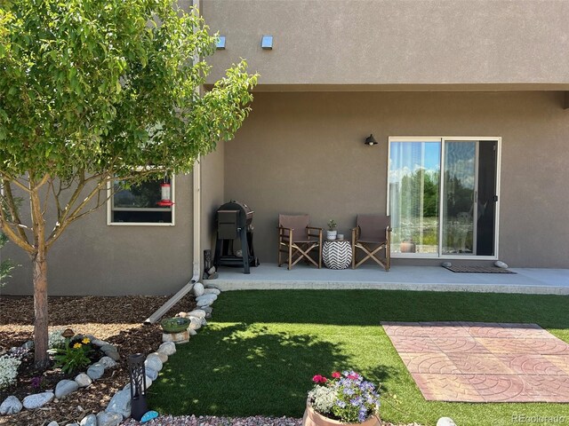 10497 Table Rock Ct, Poncha Springs, CO 81242 - back of house with stucco siding, a lawn, and a patio