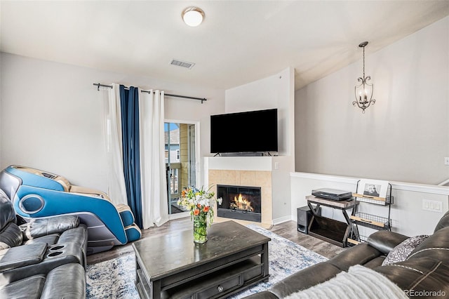 9434 Ashbury Cir Unit 204, Parker, CO 80134 - living area with wood finished floors, a tile fireplace, and baseboards