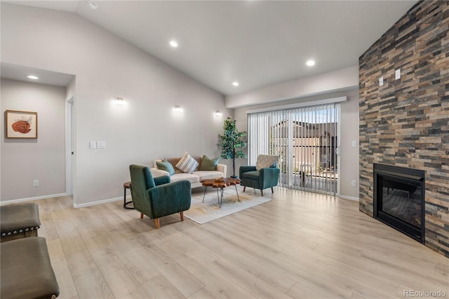 875 E 78th Ave Unit 21, Denver, CO 80229 - living area featuring lofted ceiling, light wood-type flooring, baseboards, a stone fireplace, and recessed lighting