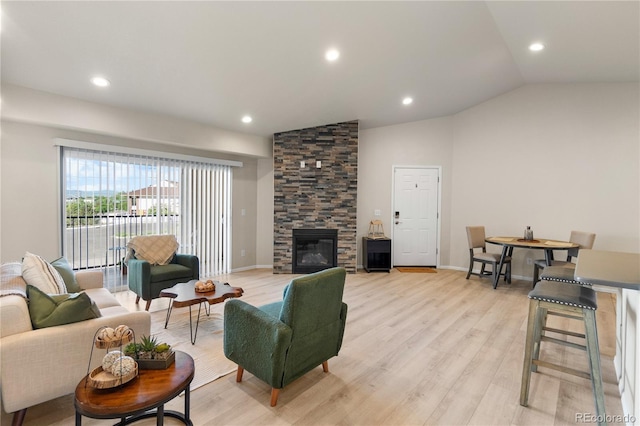 875 E 78th Ave Unit 21, Denver, CO 80229 - living area featuring light wood-style flooring, a stone fireplace, vaulted ceiling, recessed lighting, and baseboards