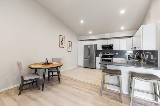 875 E 78th Ave Unit 21, Denver, CO 80229 - kitchen featuring appliances with stainless steel finishes, a sink, recessed lighting, light wood finished floors, and lofted ceiling