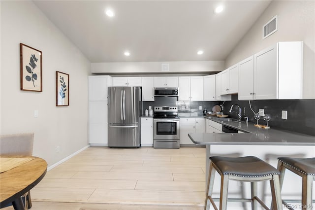 875 E 78th Ave Unit 21, Denver, CO 80229 - kitchen with appliances with stainless steel finishes, light wood-style flooring, white cabinets, backsplash, and recessed lighting