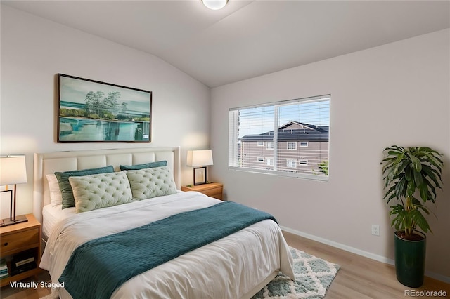 875 E 78th Ave Unit 21, Denver, CO 80229 - bedroom featuring vaulted ceiling, wood finished floors, and baseboards