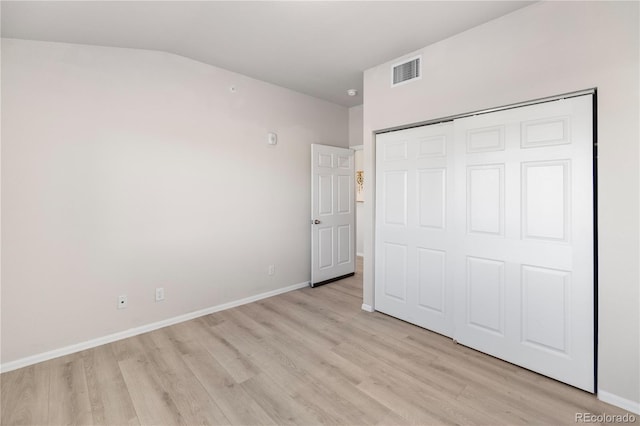 875 E 78th Ave Unit 21, Denver, CO 80229 - unfurnished bedroom featuring light wood-style flooring, baseboards, a closet, and lofted ceiling