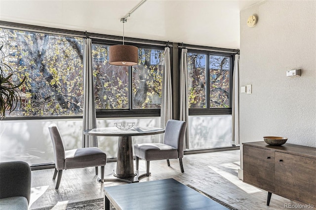 dining space featuring a textured wall and wood finished floors