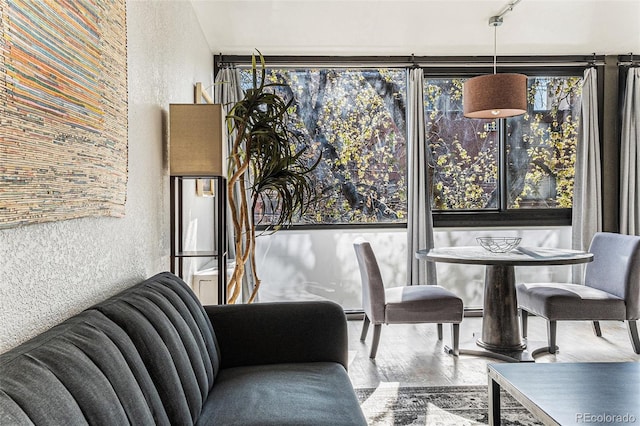 dining area with a textured wall and wood finished floors