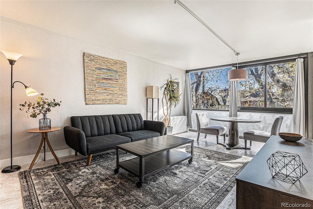 living area featuring baseboards and a textured wall