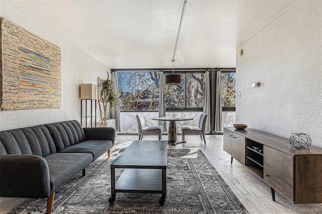 living area featuring a textured wall and wood finished floors