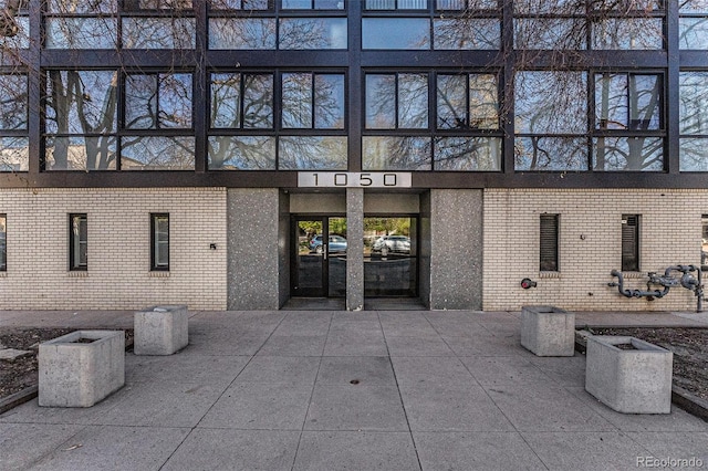 view of exterior entry featuring brick siding