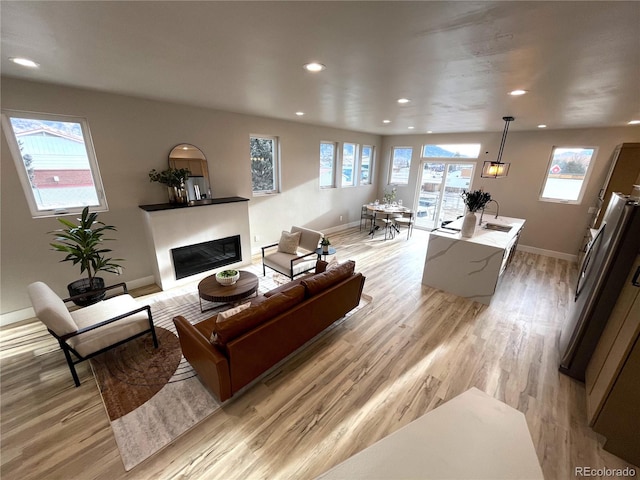 living room with light wood-type flooring and sink