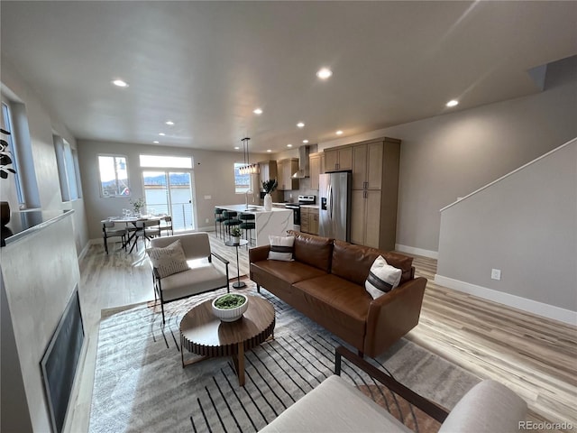 living room featuring sink, a water view, and light hardwood / wood-style flooring