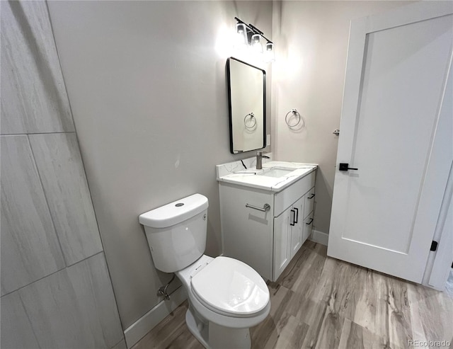 bathroom featuring vanity, hardwood / wood-style flooring, and toilet