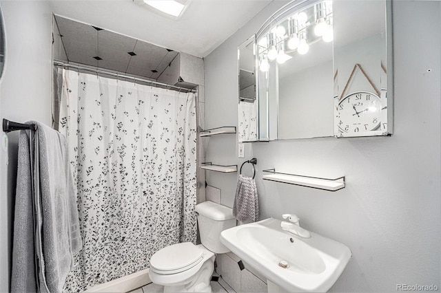 bathroom featuring toilet, a shower with curtain, and a sink