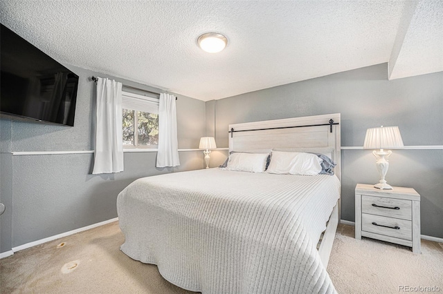 carpeted bedroom with a textured wall, baseboards, and a textured ceiling