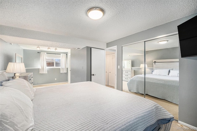 bedroom featuring two closets, a textured ceiling, and carpet