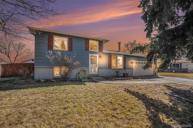 view of front of home featuring fence, driveway, an attached garage, a lawn, and brick siding