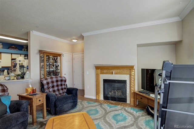 living area featuring ornamental molding, a tiled fireplace, and wood finished floors