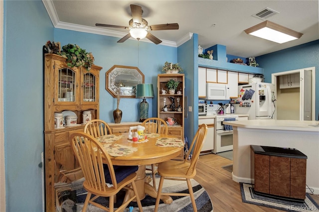 dining area featuring a ceiling fan, light wood-style flooring, visible vents, and crown molding