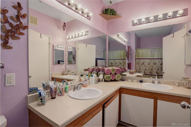 bathroom featuring double vanity, a sink, and visible vents