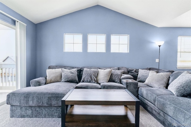 living area featuring carpet flooring and vaulted ceiling