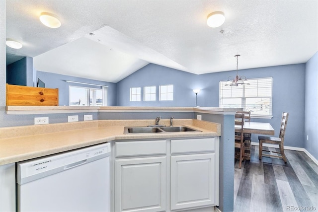 kitchen with white dishwasher, a sink, wood finished floors, a textured ceiling, and white cabinets