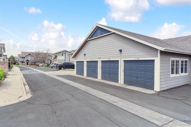 view of property exterior with community garages and a residential view