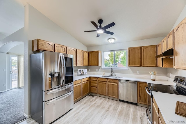 2209 S Flanders St, Aurora, CO 80013 - kitchen featuring stainless steel appliances, a sink, under cabinet range hood, vaulted ceiling, and arched walkways