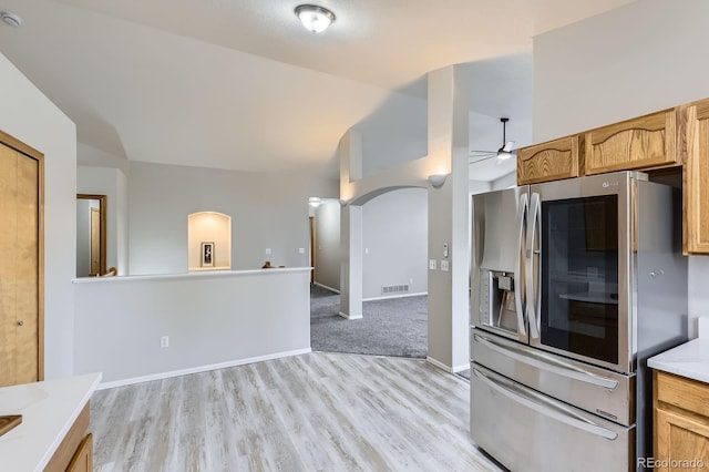 2209 S Flanders St, Aurora, CO 80013 - kitchen with stainless steel fridge, arched walkways, a ceiling fan, lofted ceiling, and light wood-style flooring