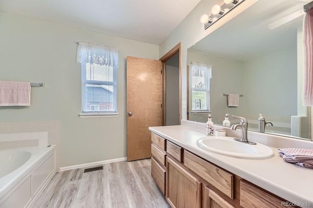 2209 S Flanders St, Aurora, CO 80013 - full bath with vanity, a garden tub, wood finished floors, and baseboards