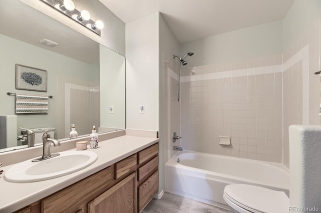 2209 S Flanders St, Aurora, CO 80013 - bathroom with toilet, vanity, tub / shower combination, and wood finished floors