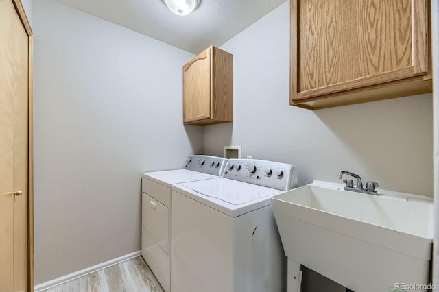 2209 S Flanders St, Aurora, CO 80013 - laundry room with cabinet space, separate washer and dryer, light wood-type flooring, and baseboards