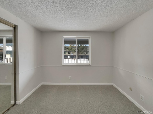 carpeted spare room with a textured ceiling