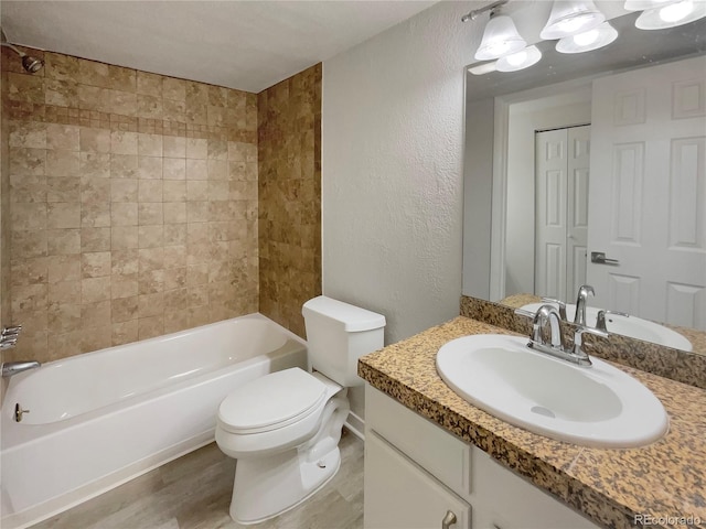 full bathroom with toilet, tiled shower / bath combo, and vanity