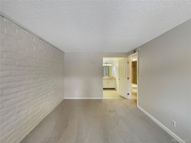 empty room featuring light carpet and a textured ceiling