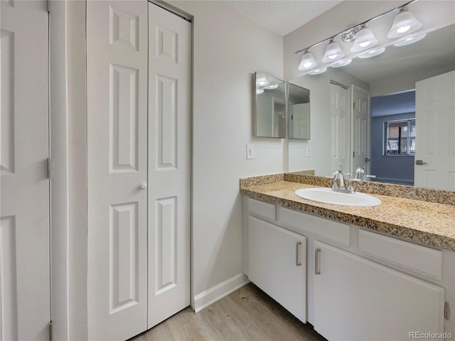 bathroom with hardwood / wood-style floors and vanity