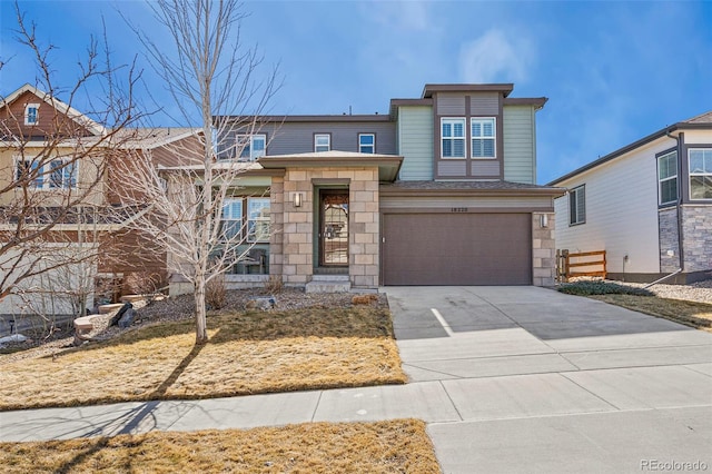 view of front of home with a garage, stone siding, and concrete driveway