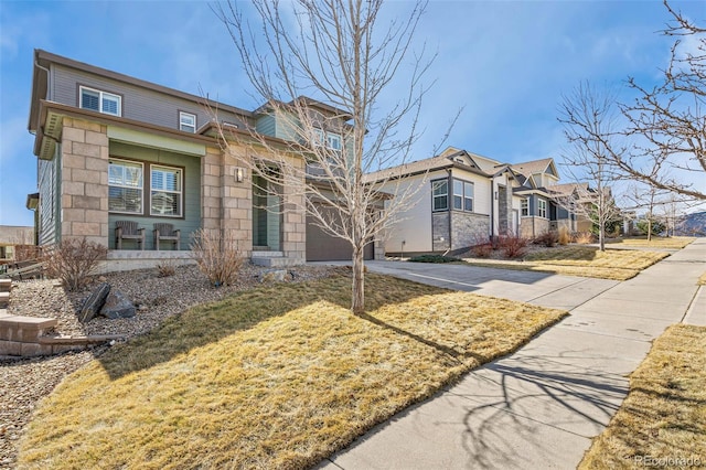 view of front of property with a garage, driveway, and stone siding