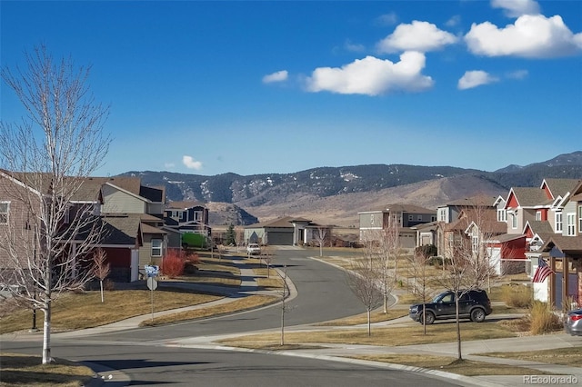 view of street with a residential view, curbs, traffic signs, sidewalks, and a mountain view